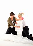 Couple having fighting in bed with pillows