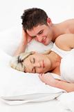Couple relaxing and smiling in bed