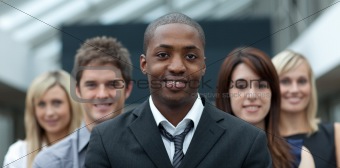 Afro-American businessman smiling at the camera with his team 