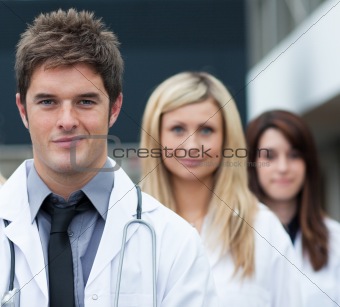 Handsome young doctor leading his team