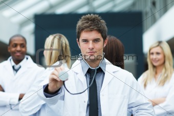 Handsome young doctor in front of his team