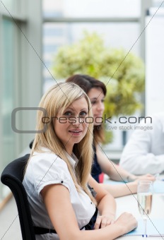 Beautiful businesswoman drinking champagne in office