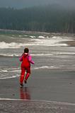 young girl in red rain clothes on ocean beach, Washngton, USA