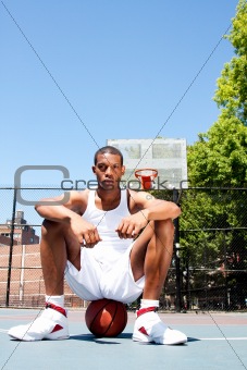 Basketball player sitting on ball