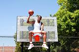 Champion basketball player sitting in hoop