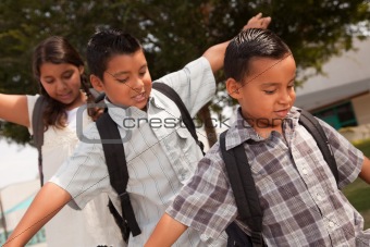 Cute Brothers and Sister with Backpacks Having Fun Walking to School.