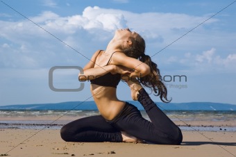 Young woman making exercise on the beach.