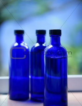 Three Blue glass body oil bottles