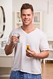 Attractive male with water and pills