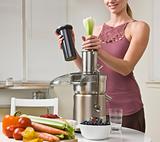 Attractive woman using juicer