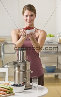 Attractive blonde with berries and juicer