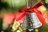 Silver bell in the christmas tree with red ribbon