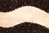Dark Roasted Coffee Beans on a Wood Textured Background.