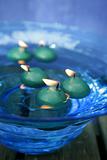 green candles over blue glass bowl of water