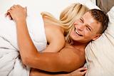 lovers happy in bed hugging each other