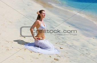 Brunette girl sitting on sand beach