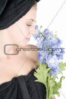 Woman with towel around hair holding flowers