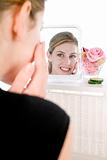 Woman applying facepack in mirror