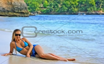 Blonde lady lying in water on the beach