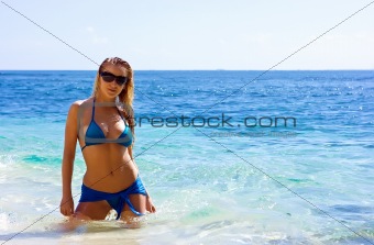 Blonde girl relaxing in water on the beach