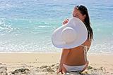 Brunette with white hat on beach
