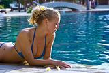 Blonde girl relaxing in water in the pool
