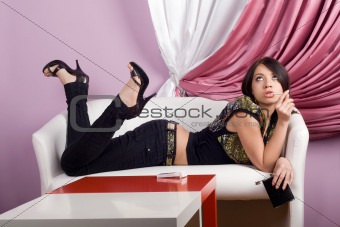 Beautiful girl lying on a white sofa
