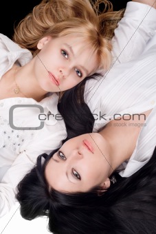 Portrait of lying beautiful young brunette and blonde