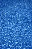 Blue water texture, tiles pool in sunny day