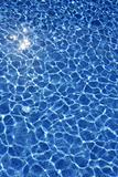 Blue water texture, tiles pool in sunny day