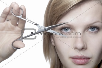 girl looks through scissors