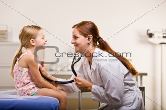 Doctor giving girl checkup in doctorÕs office