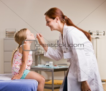 Doctor checking girlÕs temperature