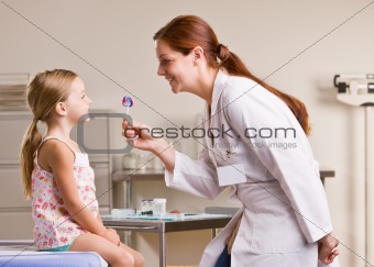 Doctor giving girl lollipop in doctorÕs office