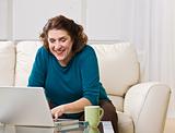 Senior woman using laptop in livingroom