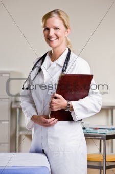 Doctor in doctorÕs office holding notebook