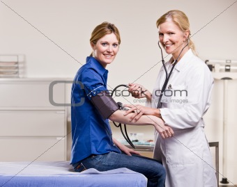 Doctor checking womanÕs blood pressure
