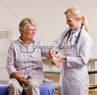 Doctor adjusting senior womanÕs wrist splint