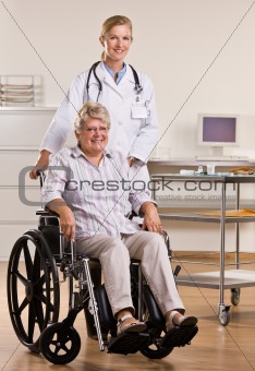 Senior woman sitting in wheelchair with doctor