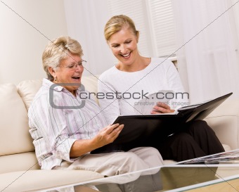 Senior woman and daughter looking at photographs
