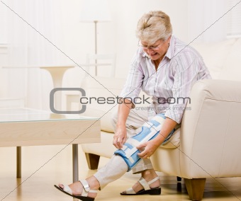 Senior woman adjusting knee brace