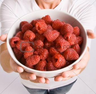 Woman holding bowl of raspberries
