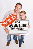 Couple holding for sale sign