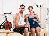 Man and woman drinking water in health club