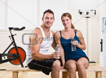 Man and woman drinking water in health club