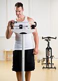 Man weighing himself in health club