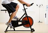 Man riding stationary bicycle in health club