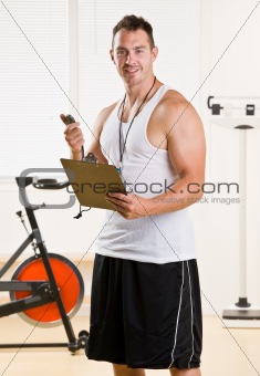 Personal trainer holding stop watch and clipboard