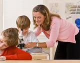 Teacher helping student with microscope
