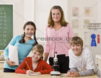 Teacher, students and microscope in classroom